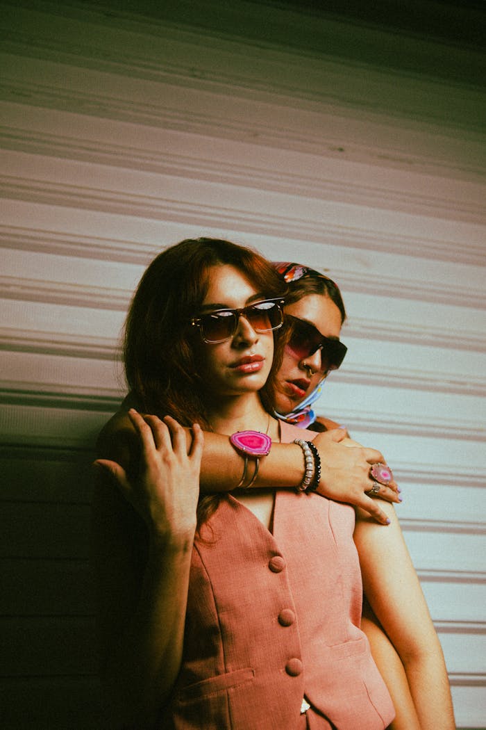 services-01 Two stylish women in sunglasses and vintage pink outfits exuding chic vibes.
